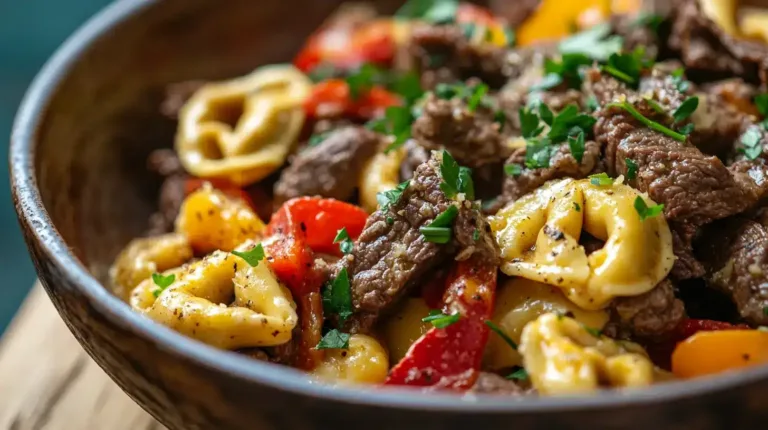 A close-up shot of Cheesesteak Tortellini with tender beef, bell peppers, and creamy cheese sauce, garnished with fresh parsley.