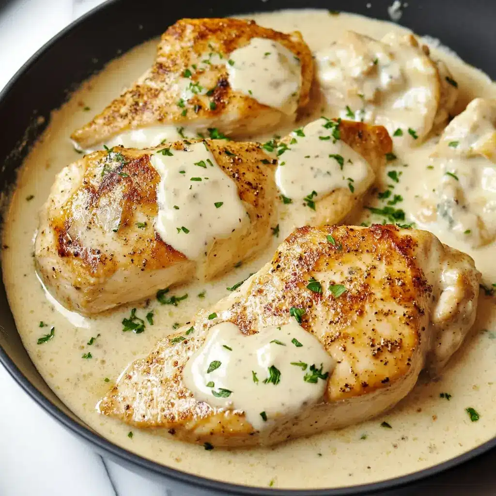Golden seared chicken breasts in a creamy sour cream sauce, topped with parsley in a skillet
