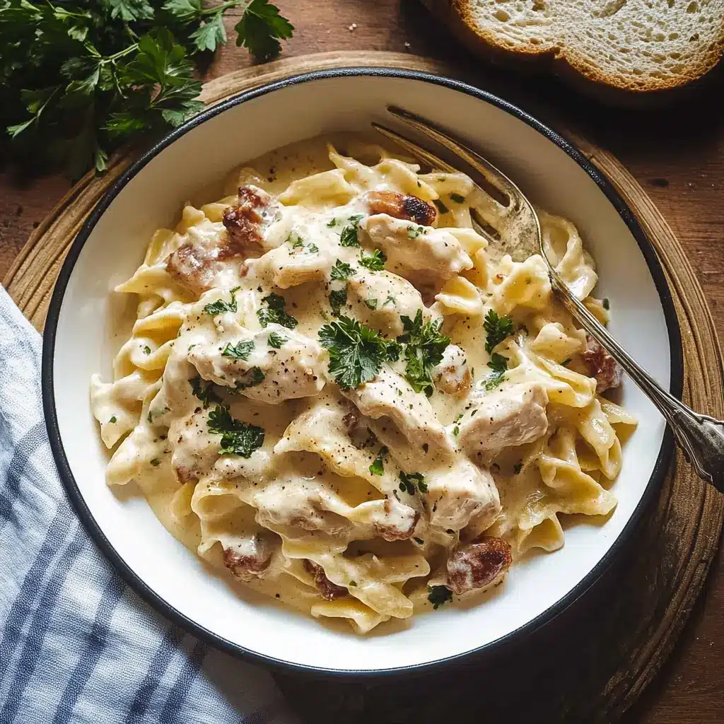 A bowl of creamy chicken alfredo pasta made with jar sauce, topped with fresh parsley and served with a fork.