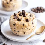 Creamy cookie dough overnight oats no peanut butter served in a glass jar with chocolate chips on top